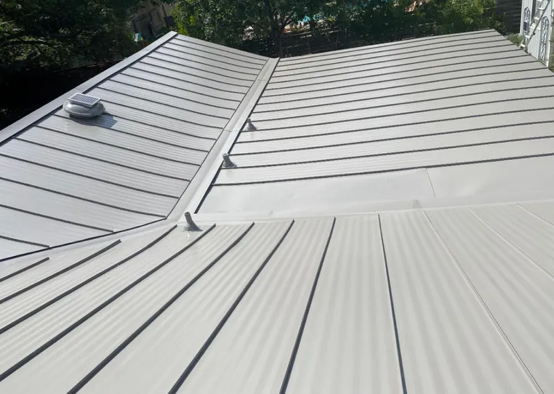 Solar attic fan installed on a metal roof for Roof Ventilation in Busti